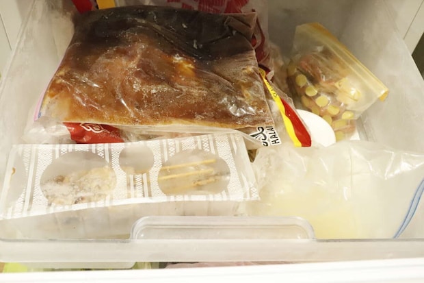 整理前の冷凍庫の引き出しにごちゃごちゃと食品が詰め込まれている