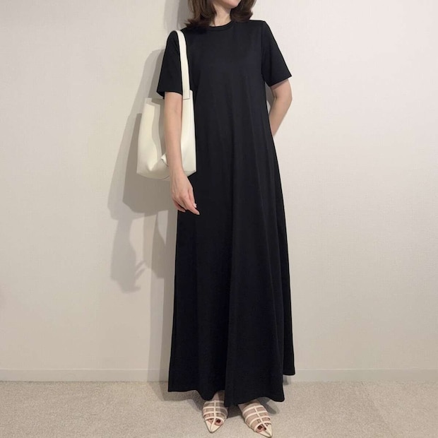 黒いワンピースに白いバッグとサンダルを合わせた女性の全身 黒いワンピースに白いバッグとサンダルを合わせた女性の全身