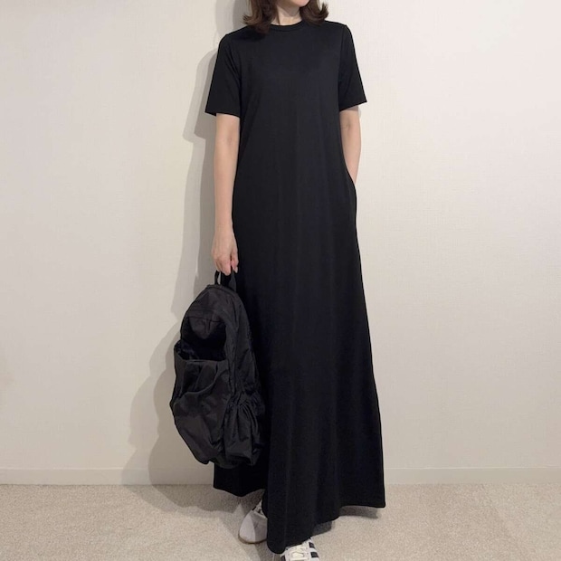 黒いワンピースに黒いリュックとスニーカーを合わせた女性の全身 黒いワンピースに黒いリュックとスニーカーを合わせた女性の全身