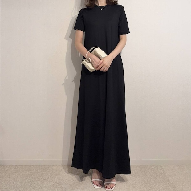 黒いワンピースに白いミニバッグとヒールサンダルを合わせた女性の全身 黒いワンピースに白いミニバッグとヒールサンダルを合わせた女性の全身