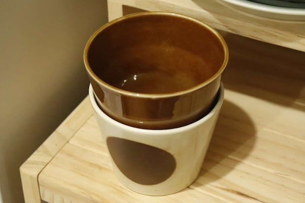 白と茶色のそばちょこが重ねて棚に収納されている 白と茶色のそばちょこが重ねて棚に収納されている