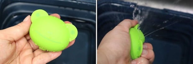 緑色の動物型水風船を握り、水を出している手のアップ