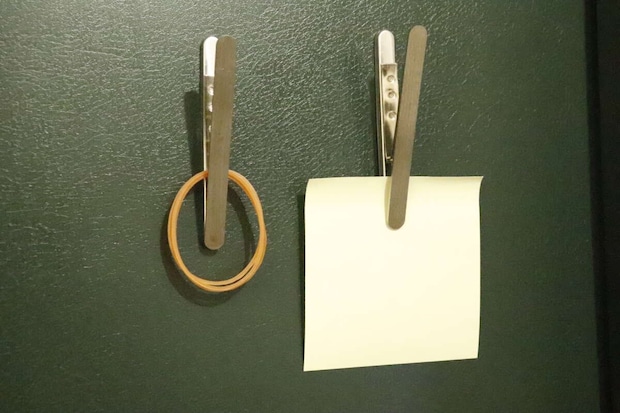 冷蔵庫に貼られたマグネットクリップで輪ゴムとメモを挟んでいる 冷蔵庫に貼られたマグネットクリップで輪ゴムとメモを挟んでいる