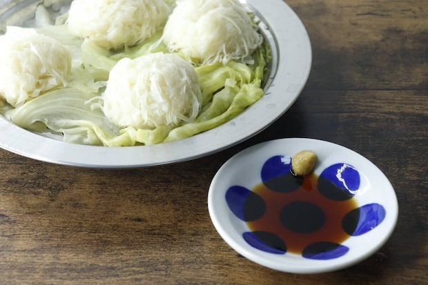 白い水玉模様の豆皿に醤油とからしが盛られ、奥に白い麺料理が置かれている 白い水玉模様の豆皿に醤油とからしが盛られ、奥に白い麺料理が置かれている