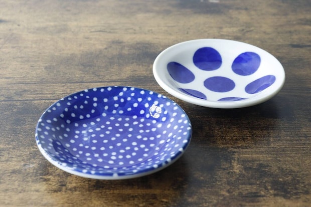 青い水玉模様と白い水玉模様の豆皿が木製のテーブルに並べられている