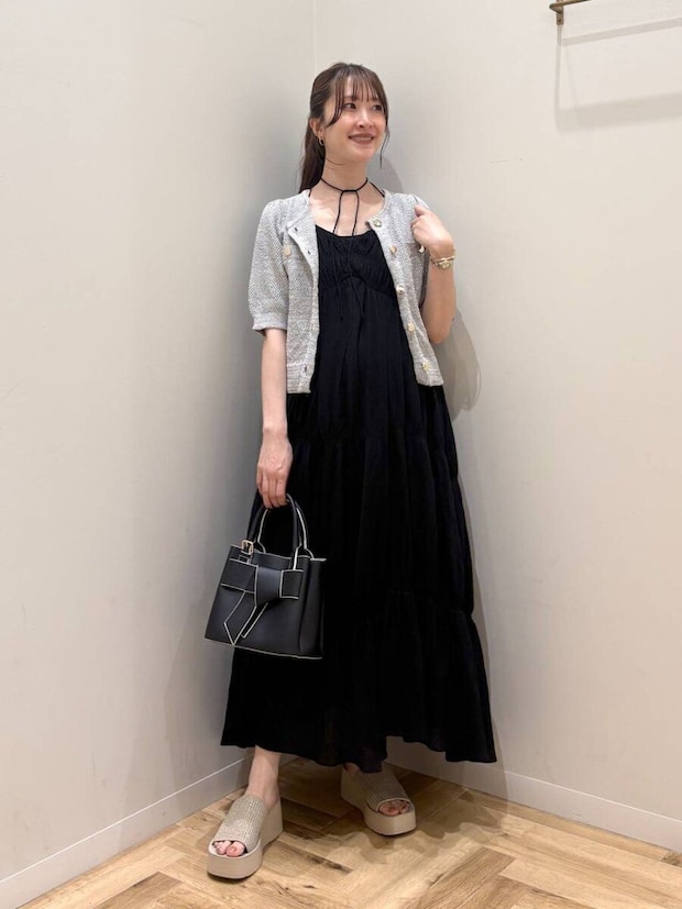 黒キャミワンピにツイード半袖カーデを羽織りハンドバッグを持つ女性 黒キャミワンピにツイード半袖カーデを羽織りハンドバッグを持つ女性