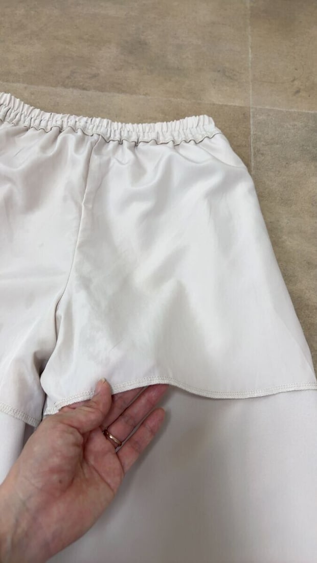 ワイドパンツの裏地を指でめくって見せている ワイドパンツの裏地を指でめくって見せている