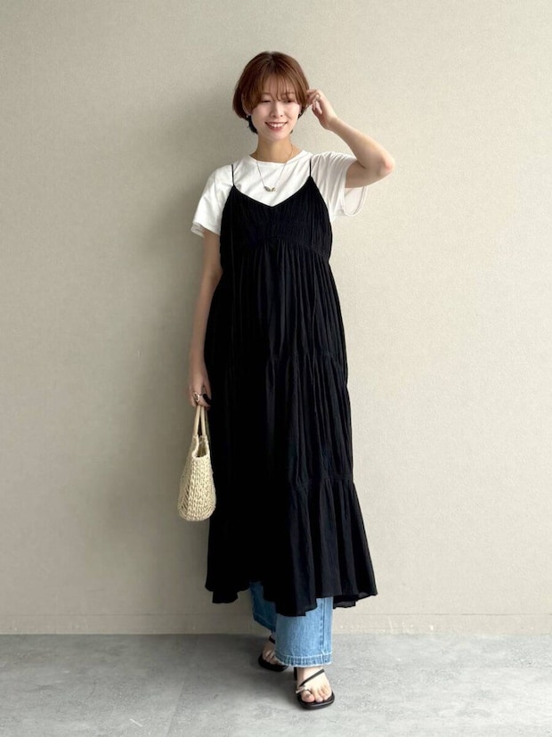 黒キャミワンピと白T、デニムを重ね着した女性が笑顔で立つ 黒キャミワンピと白T、デニムを重ね着した女性が笑顔で立つ