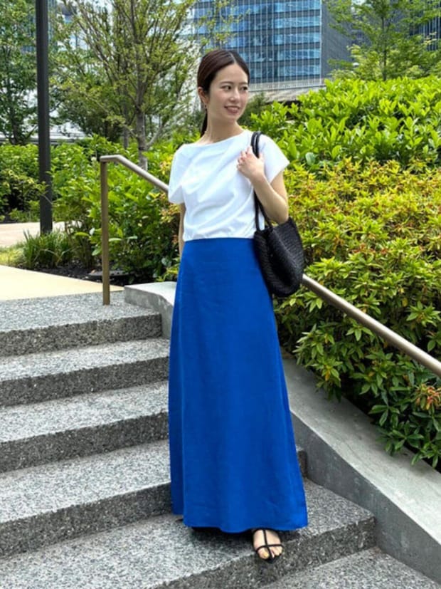 青ロングスカートと白Tを着た女性が屋外の階段で横を向く 青ロングスカートと白Tを着た女性が屋外の階段で横を向く