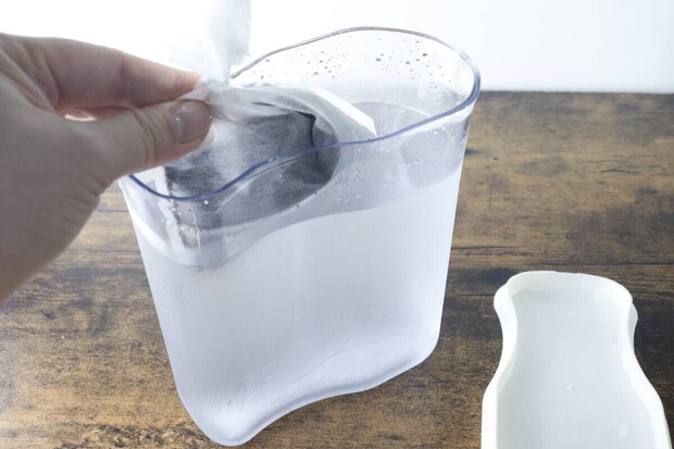 水が入ったピッチャーにコーヒー粉入りのフィルターを入れている