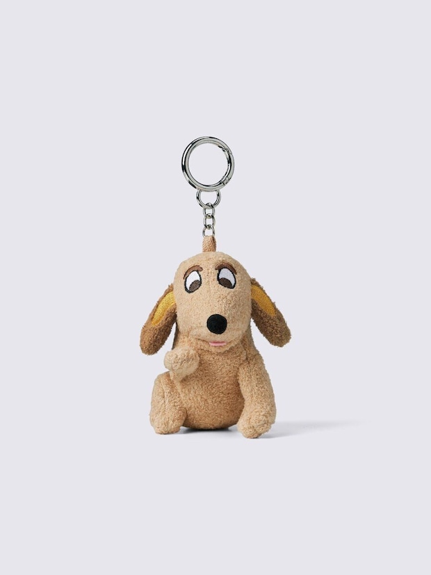 茶色の犬のぬいぐるみ型チャーム。つぶらな瞳で座っている