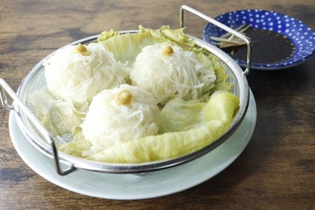 完成したシューマイが乗ったメッシュザルが皿に置かれ食卓に並ぶ 完成したシューマイが乗ったメッシュザルが皿に置かれ食卓に並ぶ