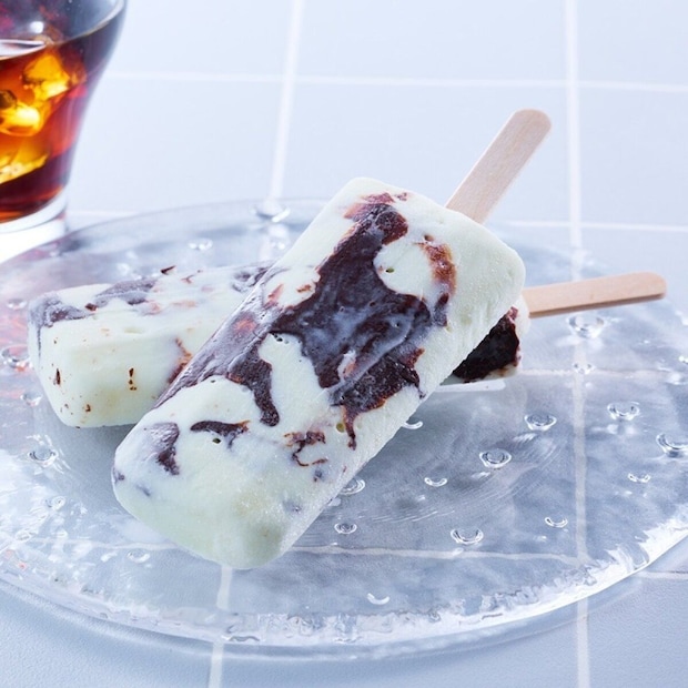 透明なガラス皿に置かれた2本のチョコバッキー。コーヒーとチョコのマーブル模様。 透明なガラス皿に置かれた2本のチョコバッキー。コーヒーとチョコのマーブル模様。
