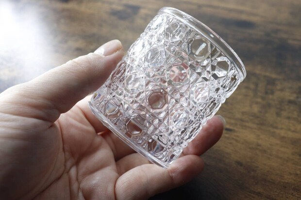 凹凸模様が特徴のミニグラスを片手で持っている様子 凹凸模様が特徴のミニグラスを片手で持っている様子