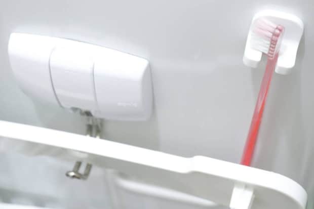 洗濯機横のラックに設置した歯ブラシキャッチに歯ブラシを掛けている様子 洗濯機横のラックに設置した歯ブラシキャッチに歯ブラシを掛けている様子