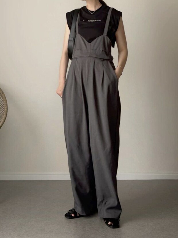 黒ノースリーブTシャツにグレーのサロペットを合わせた女性