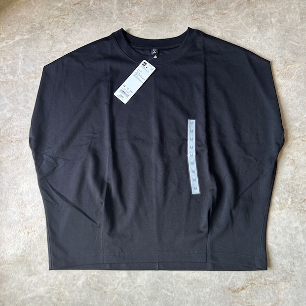 黒いGUドライウエストタックTシャツが平置きされ、タグが付いている