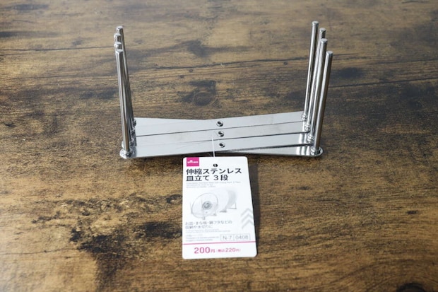 ダイソーの伸縮ステンレス皿立てが縮んだ状態で商品タグが手前に置かれている
