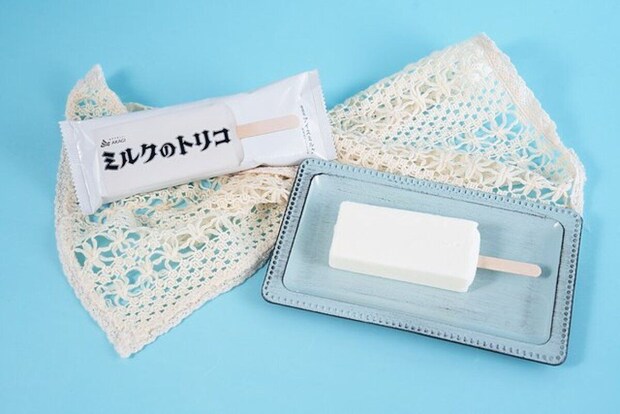 袋入りのミルクのトリコと、青い皿に置かれた白いアイスバー