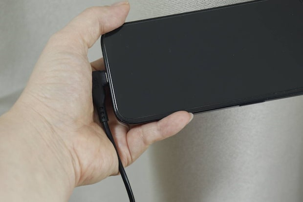 L字型コネクタをスマホに接続し横向きに持っている手元