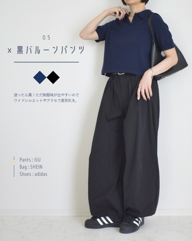 ネイビーのニットポロシャツと黒いバルーンパンツ、スニーカーを着用した女性の全身