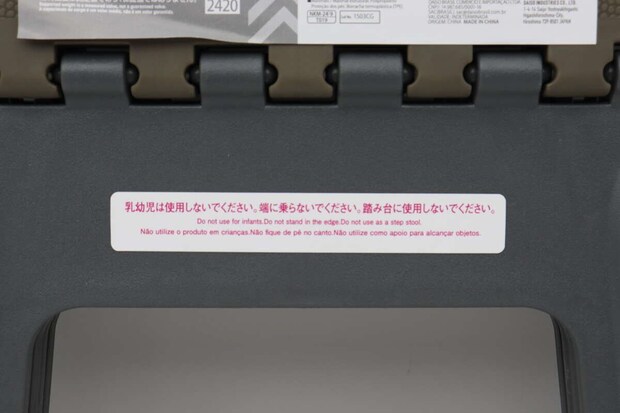 折りたたみイスの注意書きシールのアップ。「乳幼児は使用できない」など