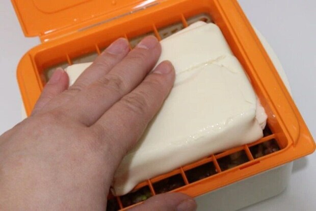 麻婆豆腐職人の容器に豆腐を押し入れてカットしている手元 麻婆豆腐職人の容器に豆腐を押し入れてカットしている手元