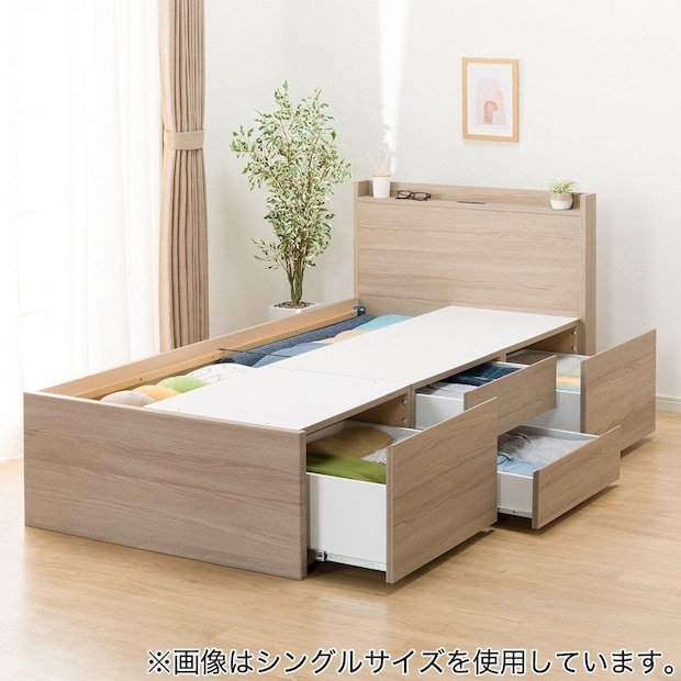 木目調のチェストベッドフレーム。引き出しが複数開いており、収納されている衣類が見える 木目調のチェストベッドフレーム。引き出しが複数開いており、収納されている衣類が見える