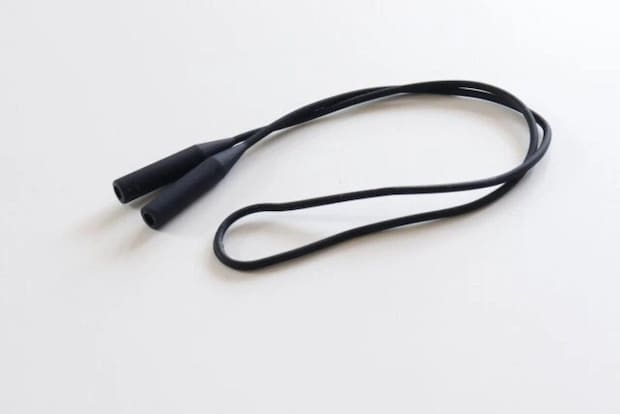 黒いシリコン製の眼鏡ストラップが白い背景に置かれている 黒いシリコン製の眼鏡ストラップが白い背景に置かれている