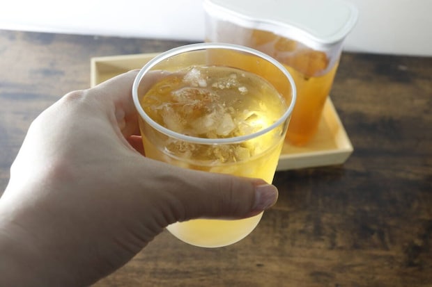 氷と飲み物が入ったグラスを手に持っている様子 氷と飲み物が入ったグラスを手に持っている様子