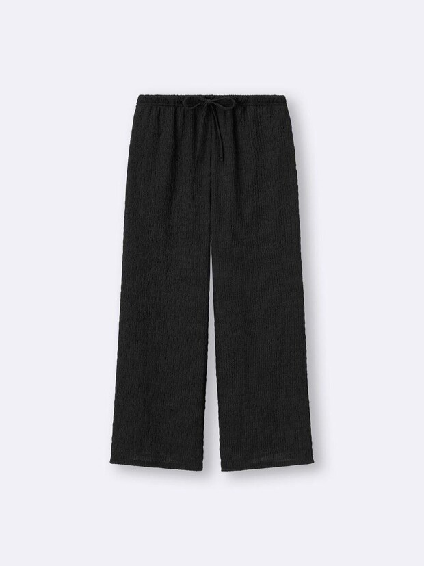 黒いシャーリングアンクルパンツ。ウエストは紐で調整可能で、全体に凹凸のある素材