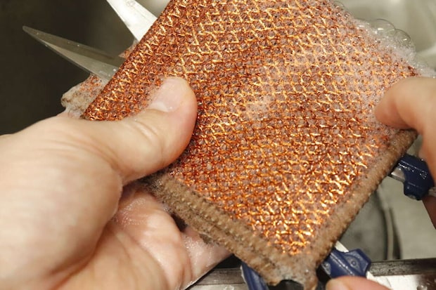 手でダイソーのメッシュクロスを握り、泡立てながらキッチンハサミを洗っている様子