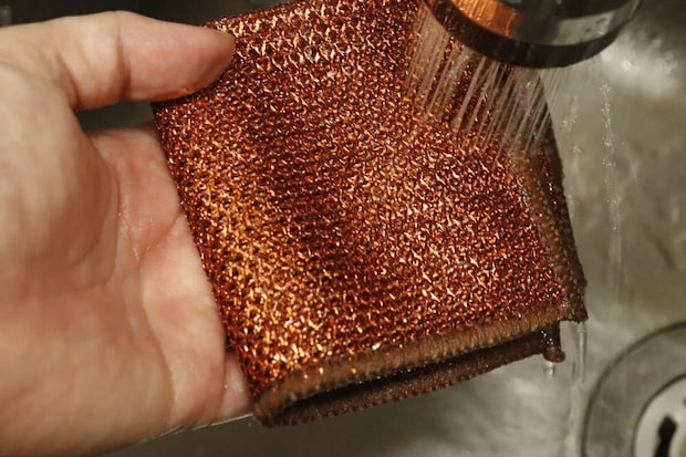 使用後のダイソーメッシュクロスを蛇口から出る水で洗い流している様子