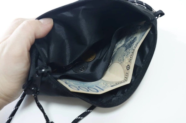 サコッシュのポケットに千円札と小銭が入っている サコッシュのポケットに千円札と小銭が入っている