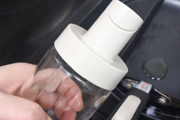 フライパンに油を注ぎ終え、蓋が自動で閉まったオイルボトル