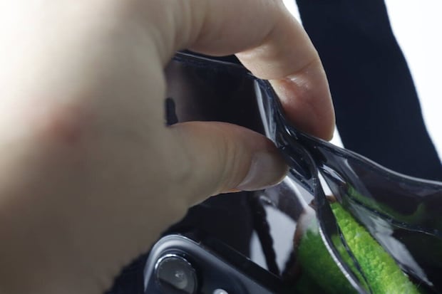 指でビニールバッグの縁をつまみ、素材の厚みを確認している