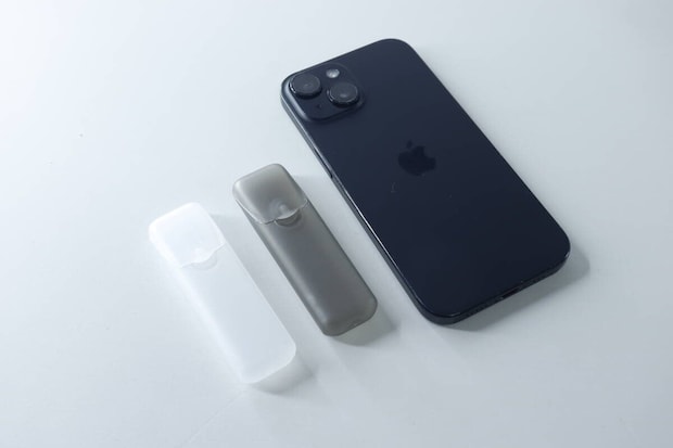 スマートフォンと並べられた白とグレーのトラベル小物ケース2個