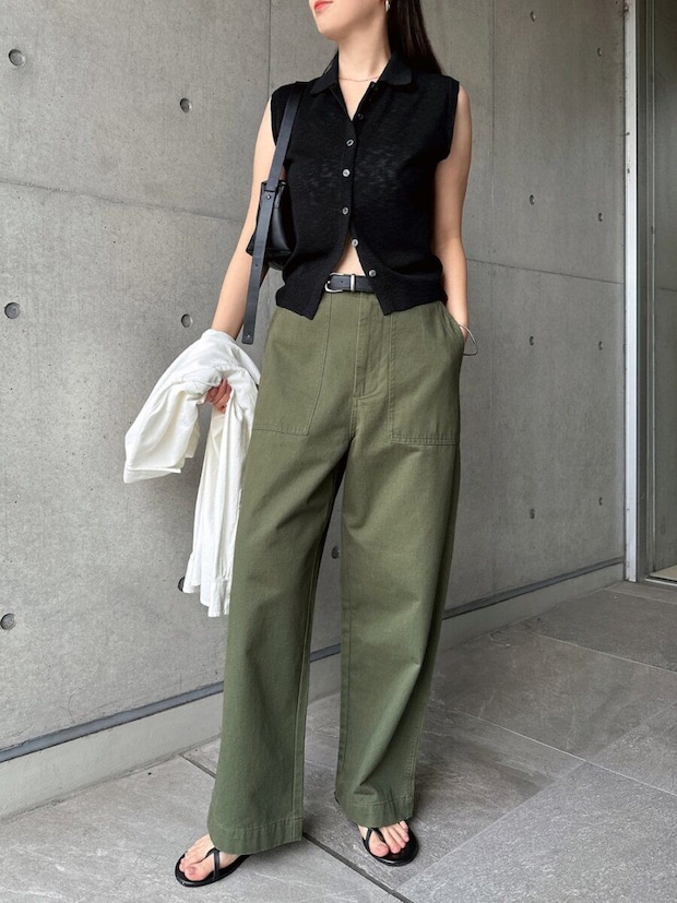 透け感黒ニットとカーキワイドパンツ、黒バッグを持った女性