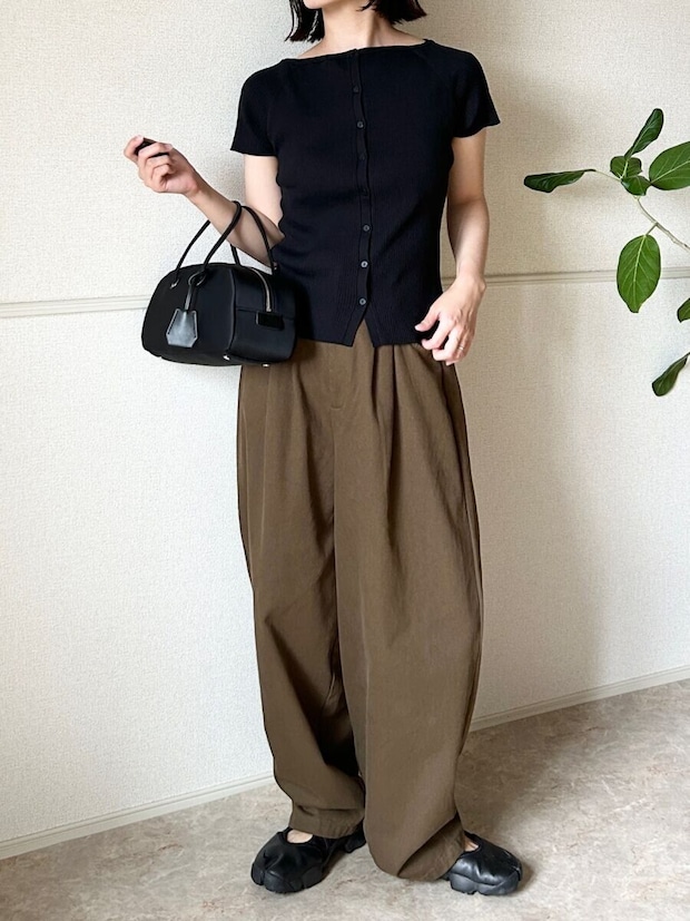 黒カーデとワイドパンツ、黒スニーカーの女性