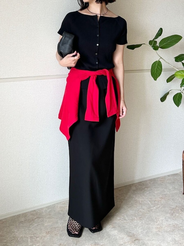 黒カーデと黒スカートに赤いカーデを腰巻きした女性 黒カーデと黒スカートに赤いカーデを腰巻きした女性