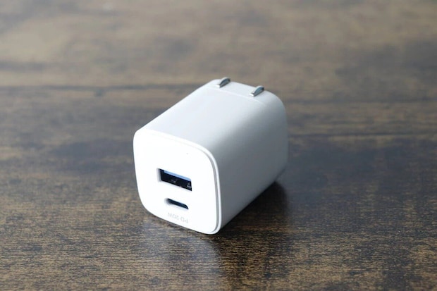 白いGaN USB充電器が木目調のテーブルに置かれている 白いGaN USB充電器が木目調のテーブルに置かれている