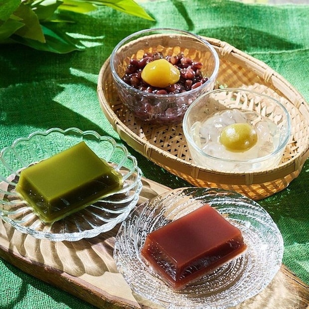 緑の布の上に水ようかんやぜんざい、くずきりなどの和菓子が並ぶ