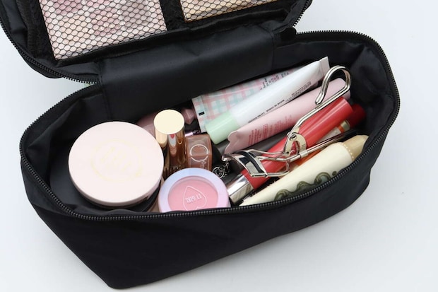 黒いメイクポーチのメイン収納にコスメがたっぷり入っている