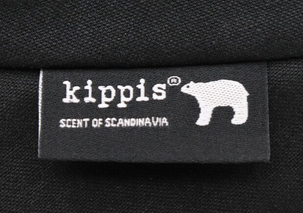 黒い生地に白文字で「kippis」とシロクマのロゴが縫い付けられている 黒い生地に白文字で「kippis」とシロクマのロゴが縫い付けられている