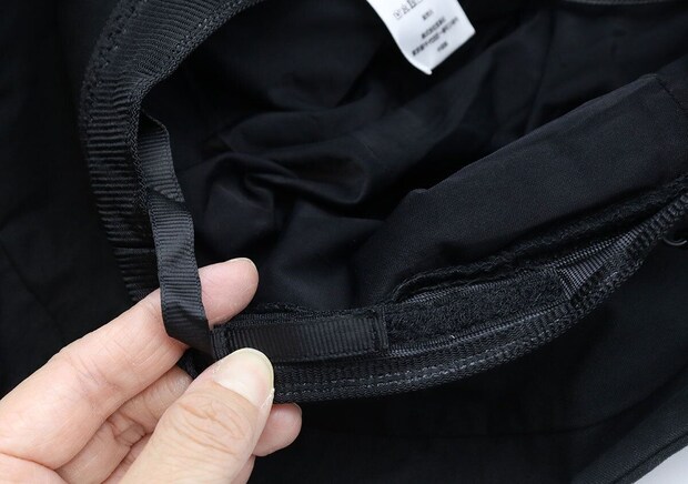 指でハット内側の面ファスナー式アジャスターを調整している手元 指でハット内側の面ファスナー式アジャスターを調整している手元