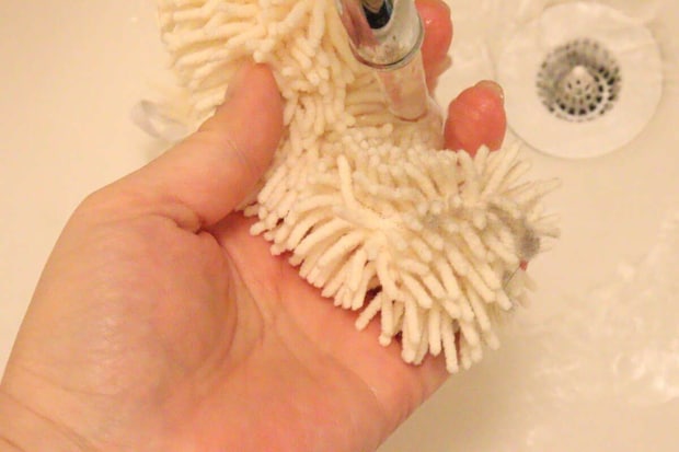 流水で汚れたハンディモップを洗っている手元