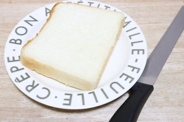 白い皿に乗った食パンと、その横に置かれたパンスライサー