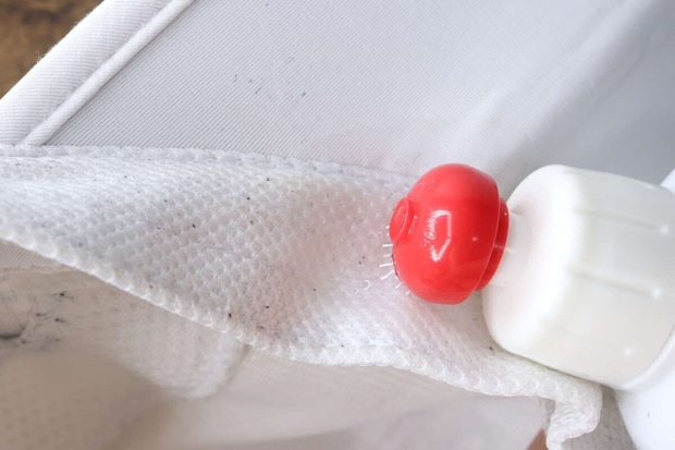 帽子の内側の黄ばんだ部分に洗剤の先端を当てて塗布している 帽子の内側の黄ばんだ部分に洗剤の先端を当てて塗布している