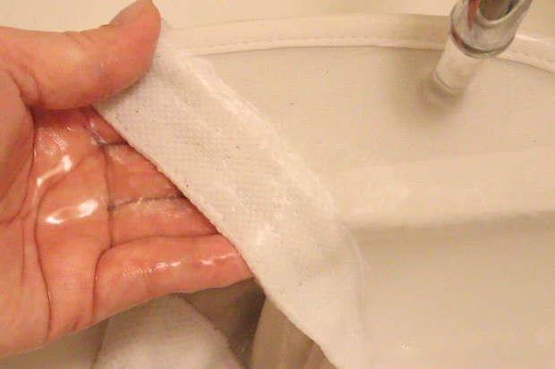 洗剤を塗った帽子の内側を水で濡らしながら手で揉み洗いしている
