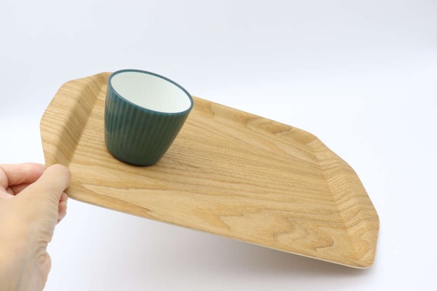 手で傾けたトレーにプラスチックコップが安定している様子 手で傾けたトレーにプラスチックコップが安定している様子